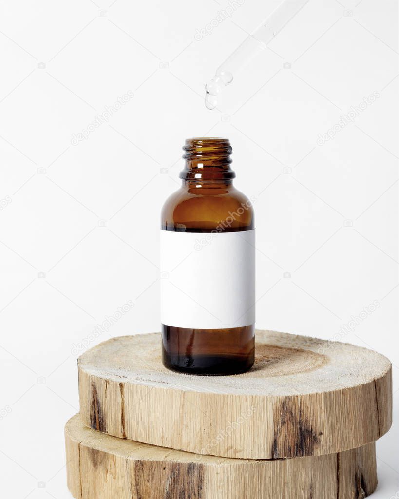Brown glass skin care bottle decorate with wood on white background photo
