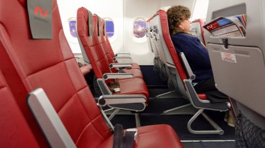 Yekaterinburg / Rusya - 16 Mart 2020: Nordwind Havayolları yolcuları uçuştan önce kırmızı koltuklarda oturuyorlar.