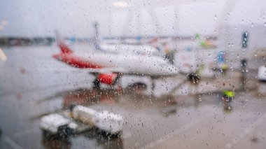 Saint-Petersburg / Rusya - 16 Mart 2020: Havalimanı penceresinden yağmur damlaları aktı. Bulanık bir arkaplanda, Rossiya Havayolları kapıda. Yağmurlu bir hava. Gri gökyüzü.