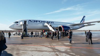 Saint-Petersburg / Rusya - 17 Mart 2020: Airbus A350-900 Aeroflot. Uçağa giden merdiven aracındaki yolcular.