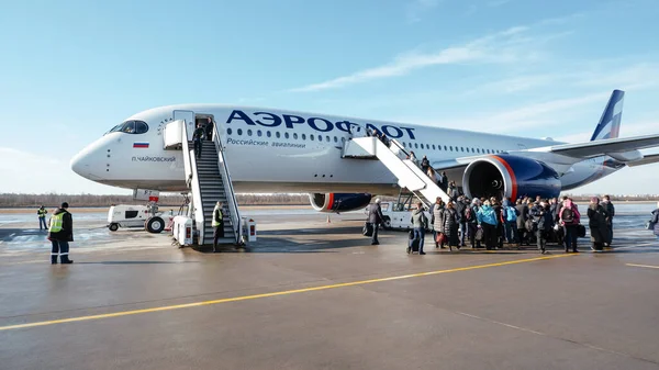 Saint-Petersburg / Rusya - 17 Mart 2020: Airbus A350-900 Aeroflot. Uçağa giden merdiven aracındaki yolcular.