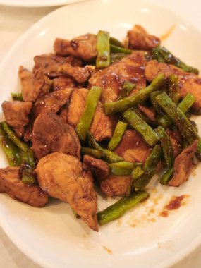 Çin yemeği, heyecan uzun fasulye ile beyaz tabakta tavuk kızarmış.