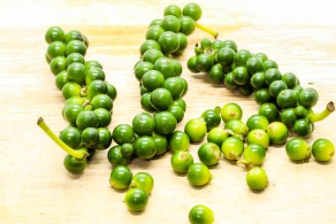 Taze yeşil peppercorns bir kahverengi ahşap, yakın çekim