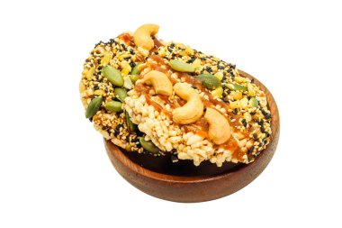 Tahta fincanda birkaç tahıl gevreği olan iki tane çıtır pirinç krakeri yakın.