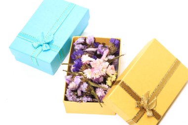 Altın hediye kutusu ve mavi hediye kutusu olan renkli kuru çiçeğe yakın çekim