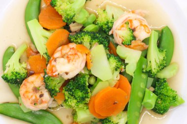 Tay gıda beyaz plaka üzerinde karides ile kızarmış brokoli karıştırın