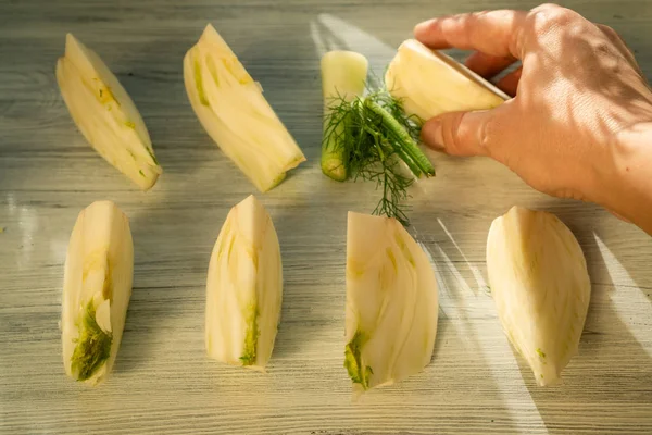 Beyaz ahşap yüzeyde dilimlenmiş rezene dilimleri koleksiyonu. 