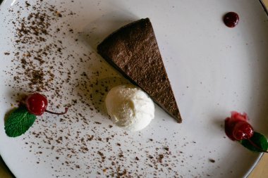 Çikolatalı kek, beyaz tabakta dondurma topu.