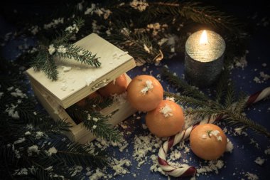 Noel hediyesi olarak bir kutuda şeker ve mandalina. 