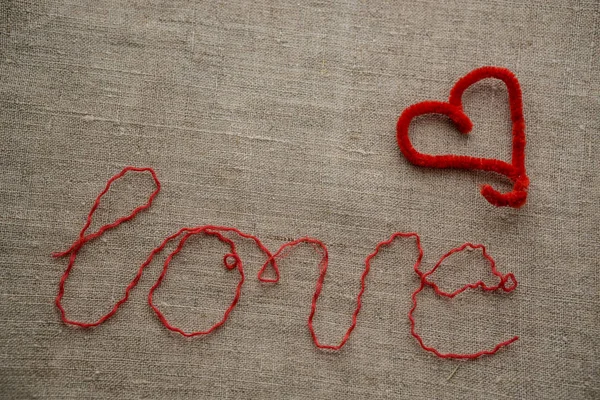 Heart made of red material on a linen surface. — Stock Photo, Image