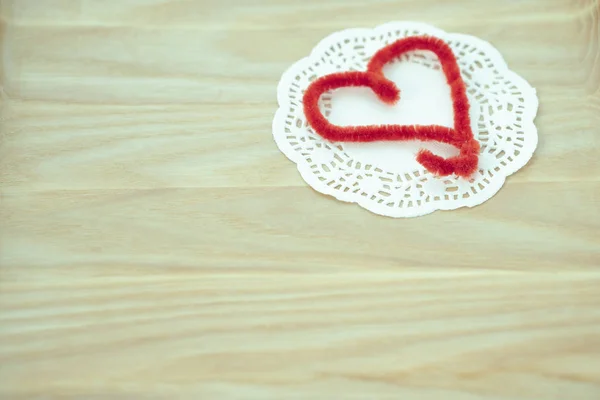 Red heart on white napkin on a wooden surface. — Stock Photo, Image