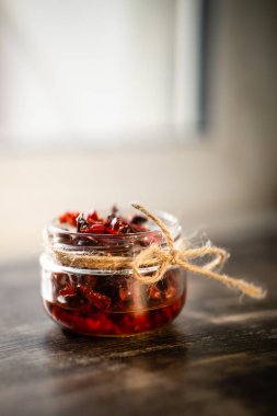 Arka planda bir çocuğun elinde kurutulmuş domates kavanozu.