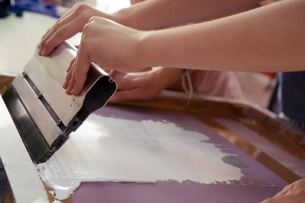 Spatula ya da bıçak, çizim yapmak ya da elle baskı yapmak için esnetilmiş bir tuvale kalın boya sürmek için. Eller kumaş çizmek için yaratıcı işler yapıyor..