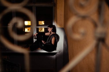 Gece gökyüzü pencerenin dışında ve güzel üzgün yalnız kadın dar