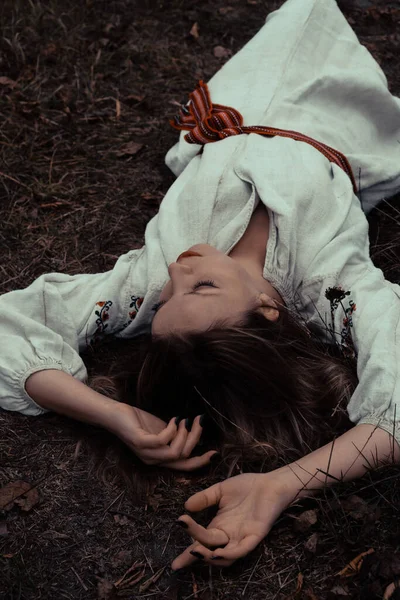Beautiful baby girl lies on dry grass in the garden