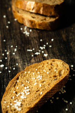 Tahta yüzeyde tuzlu taze bir dilim siyah ekmek. Çavdar unlu veya mayalı sağlıklı yiyecekler..