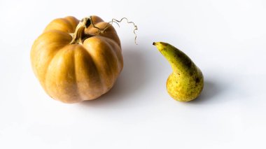 Beyaz bir yüzeyde, vejetaryen yiyecekler için gerekli malzemelerin olduğu bir hayat. Sebze kabağı ve meyve armudu konferansı sağlıklı yemek menüsü üzerine..