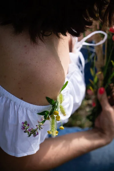 裸露的女性肩部 有一小束野草和花朵装饰的痣 温柔的对待女性的身体 — 图库照片