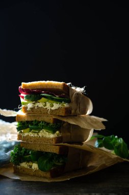 Hindiba ve mısır salatası, avokado ve salatalık dilimli vejetaryen piknik sandviçi.