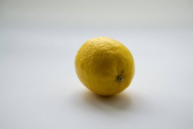 Beyaz yüzeyde tam limon meyvesi. İlkbahar enerjisi doldurmak için sarı sitrik meyvelerde vitaminler.
