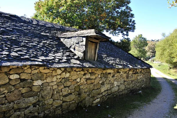 Каменный дом с черной крышей — стоковое фото