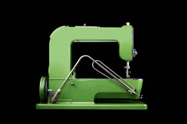 Siyah arkaplanda eski bir yeşil dikiş makinesinin yan görünümü