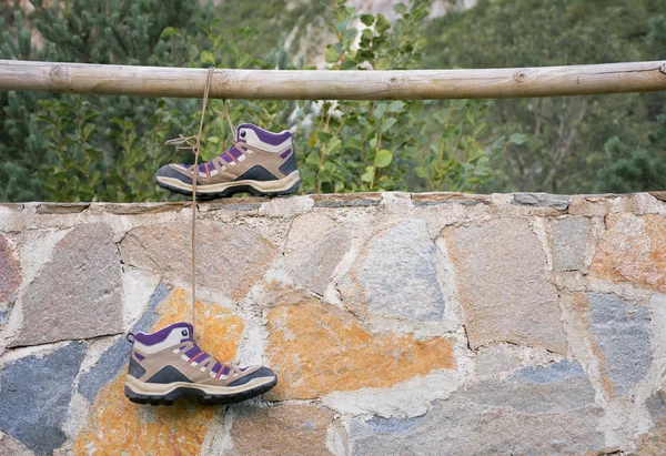 Pair Boots Tied Each Other Hanging Railing Laces Leaning Stone — Stock Photo, Image