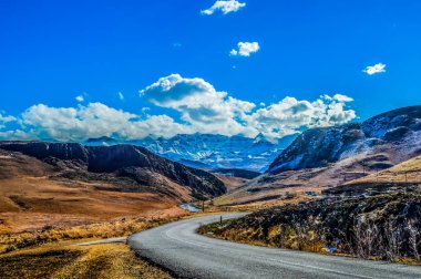 Resim mükemmel kar Drakensberg Dağları şapkalı ve Güney Afrika Underberg Sani yakınındaki yeşil düzlükler geçmek