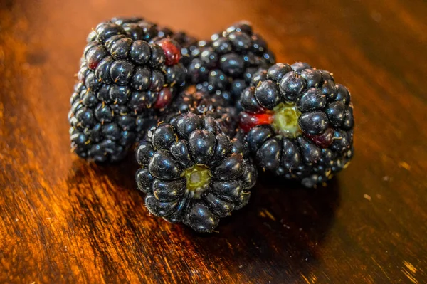 Macro shot of organic and healthy blackberry , blackberries on a wooden brown background