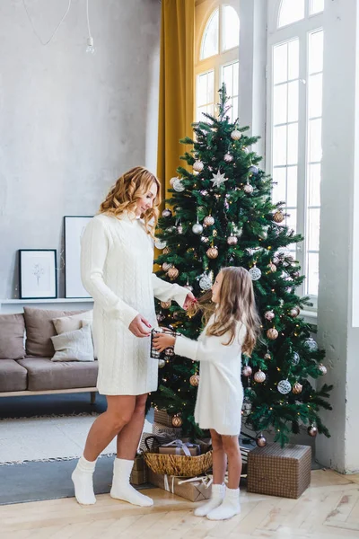 Une fille avec sa mère près du sapin de Noël, l'intérieur décoré pour la nouvelle année et Noël, famille et joie, traditions — Photo