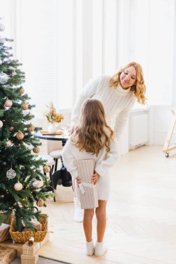Annesiyle Noel ağacının yanında bir kız, yeni yıl ve Noel için dekore edilmiş, aile ve neşe, gelenekler