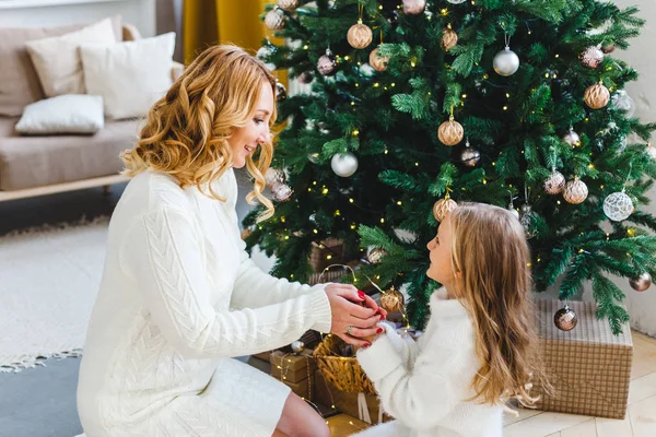 Une fille avec sa mère près du sapin de Noël, l'intérieur décoré pour la nouvelle année et Noël, famille et joie, traditions — Photo