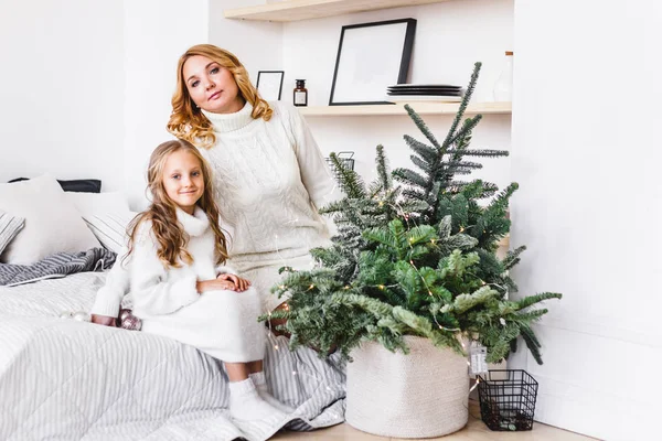 Une fille avec sa mère près du sapin de Noël, l'intérieur décoré pour la nouvelle année et Noël, famille et joie, traditions — Photo