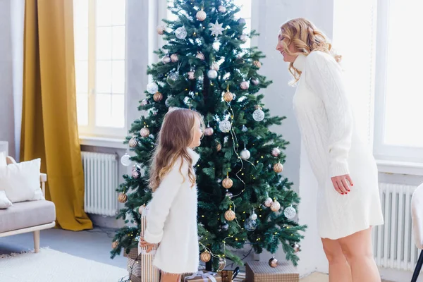 Une fille avec sa mère près du sapin de Noël, l'intérieur décoré pour la nouvelle année et Noël, famille et joie, traditions — Photo