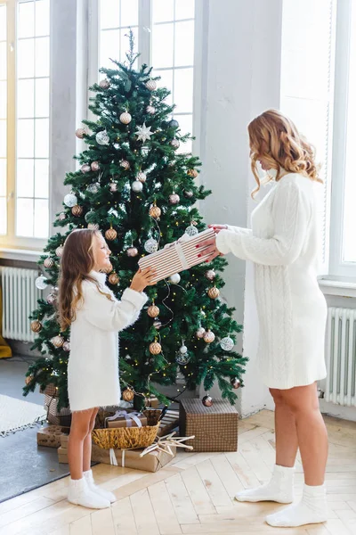 Une fille avec sa mère près du sapin de Noël, l'intérieur décoré pour la nouvelle année et Noël, famille et joie, traditions — Photo