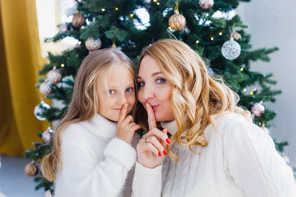 Une fille avec sa mère près du sapin de Noël, l'intérieur décoré pour la nouvelle année et Noël, famille et joie, traditions — Photo