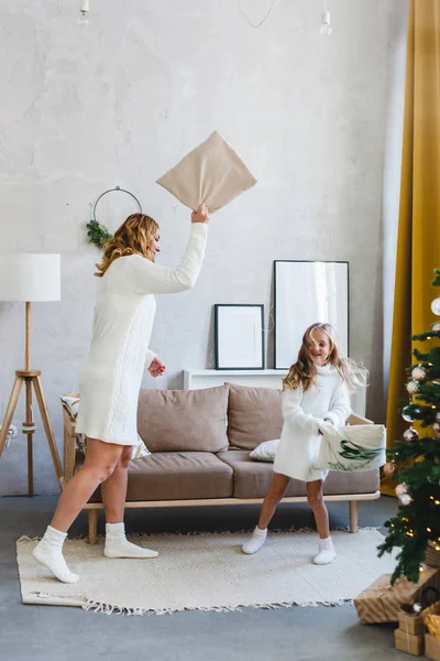 La fille et sa mère jouent avec l'oreiller, l'arbre de Noël et l'intérieur de Noël et du Nouvel An — Photo
