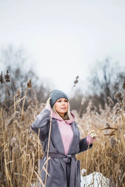 Portrét dívky evropského vzhledu na zimní procházce, tráva, les, pole, klobouk, zdraví — Stock fotografie