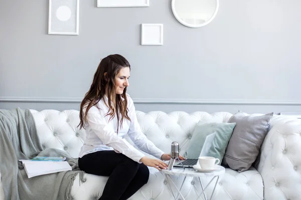 Portrait of a girl in a bright interior, a girl of European appearance sitting on the couch, Manager, freelancer — ストック写真