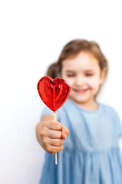 Little girl holding a Lollipop in the shape of a heart, lovers, Valentine's day, family and heart — Stock Photo, Image