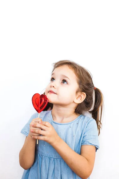 Little girl holding a Lollipop in the shape of a heart, lovers, Valentine's day, family and heart — Stock Photo, Image