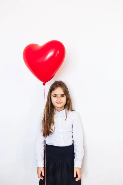 Chica de aspecto europeo sobre un fondo blanco sosteniendo un globo en forma de corazón, globo, corazón, amor, día de San Valentín, cumpleaños, vacaciones —  Fotos de Stock