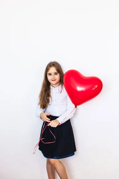 European-looking girl on a white background holding a heart-shaped balloon, balloon, heart, love, Valentine 's day, birthday, holiday — стоковое фото