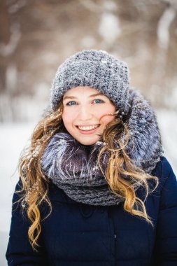 Avrupa görünümlü bir kız parkta yürüyor, orman, kış ve kar, kalın kıyafetler, şapka, ceket, atkı, dinlenme, yürüyüş