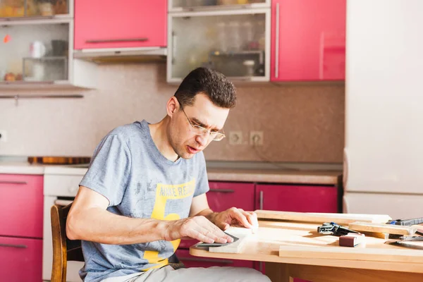 a man at home in quarantine makes wood decor elements for home, kitchen, Studio, creating with his hands, time with family