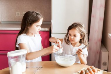 Kardeşler kahvaltı hazırlar, hamur işleri, un, süt, yumurta, gözleme kasede, çocuklar annelere yardım eder, aile kahvaltısı yapar, yemek yapar.