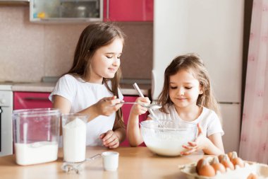 Kardeşler kahvaltı hazırlar, hamur işleri, un, süt, yumurta, gözleme kasede, çocuklar annelere yardım eder, aile kahvaltısı yapar, yemek yapar.