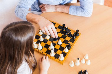 Kız ve baba evde bir oyun oynuyor, satranç, beyin gelişimi için bulmaca, zihinsel zeka, çocuk gelişimi, okul, ev, karantina, tatil, aile ile zaman geçirme