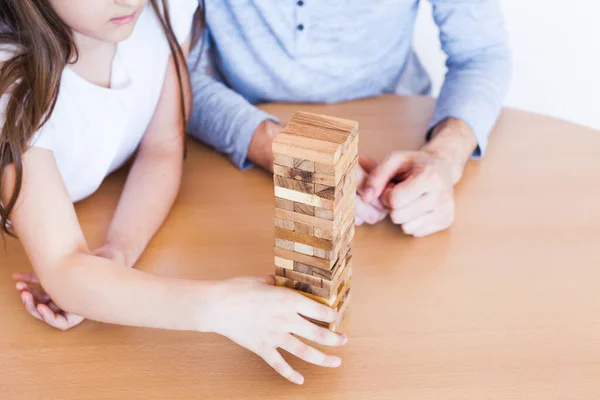 女孩和爸爸在家里玩游戏 花费了一堆块 立方体 Jenga 智力发展难题 智力发展 儿童发展 和家人在一起的时间 — 图库照片