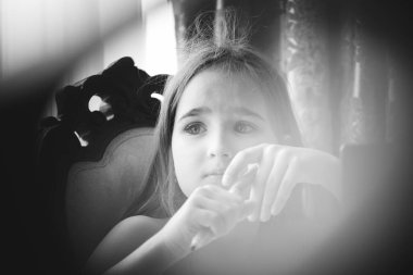 Bir kız masada oturuyor, çizgi film, film, program, hobi, el işi, ev, aile ve çocuk izliyor.